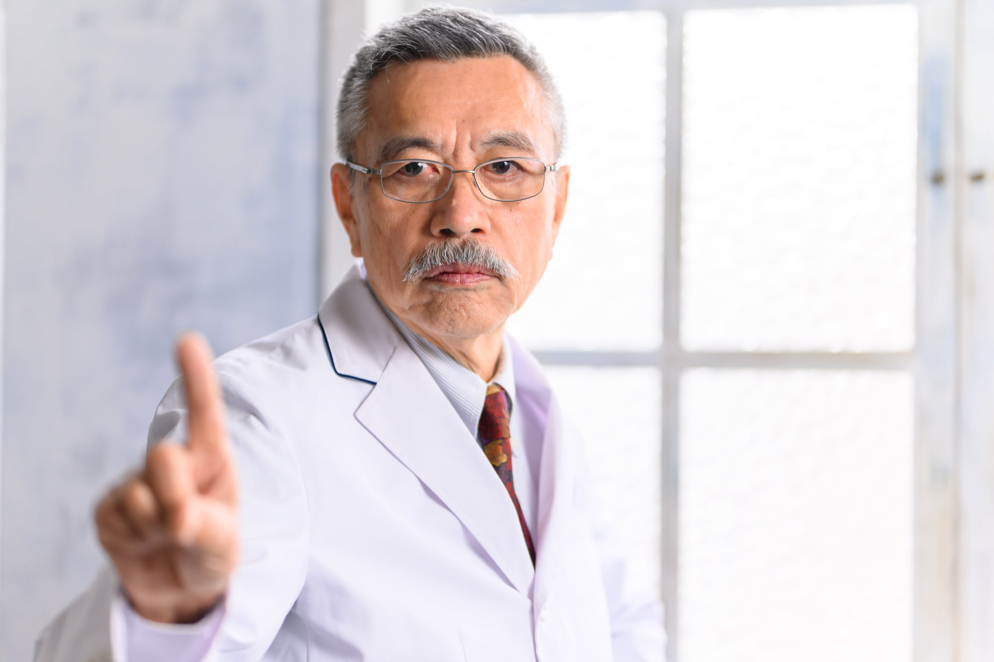 高齢者がインプラント治療を選択する場合の注意点を説明する歯科医