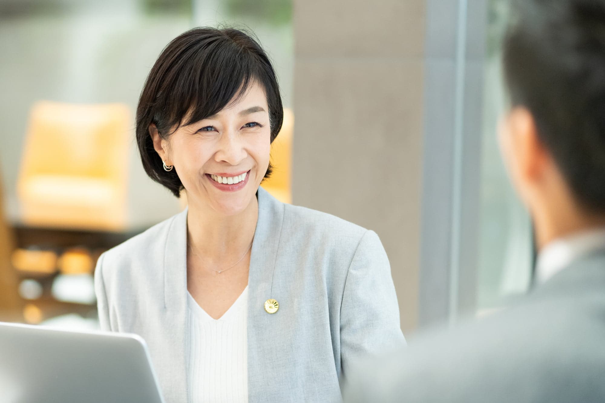 奥歯をインプラント治療して笑顔で仕事をする女性