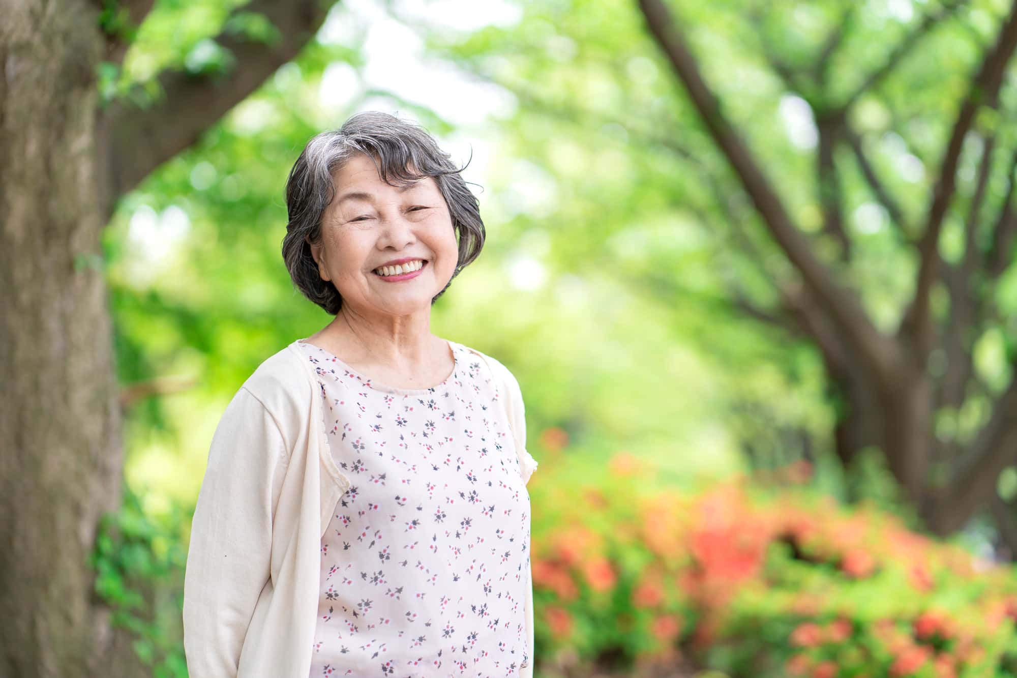 インプラント治療後に適切な歯みがきケアを行い良好な状態を保っている笑顔のシニア女性